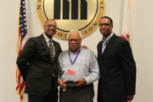 NHA President & CEO Rudolph A. Johnson stands with former Board Chair Gil Johnson and new Board Chair Vic Baker